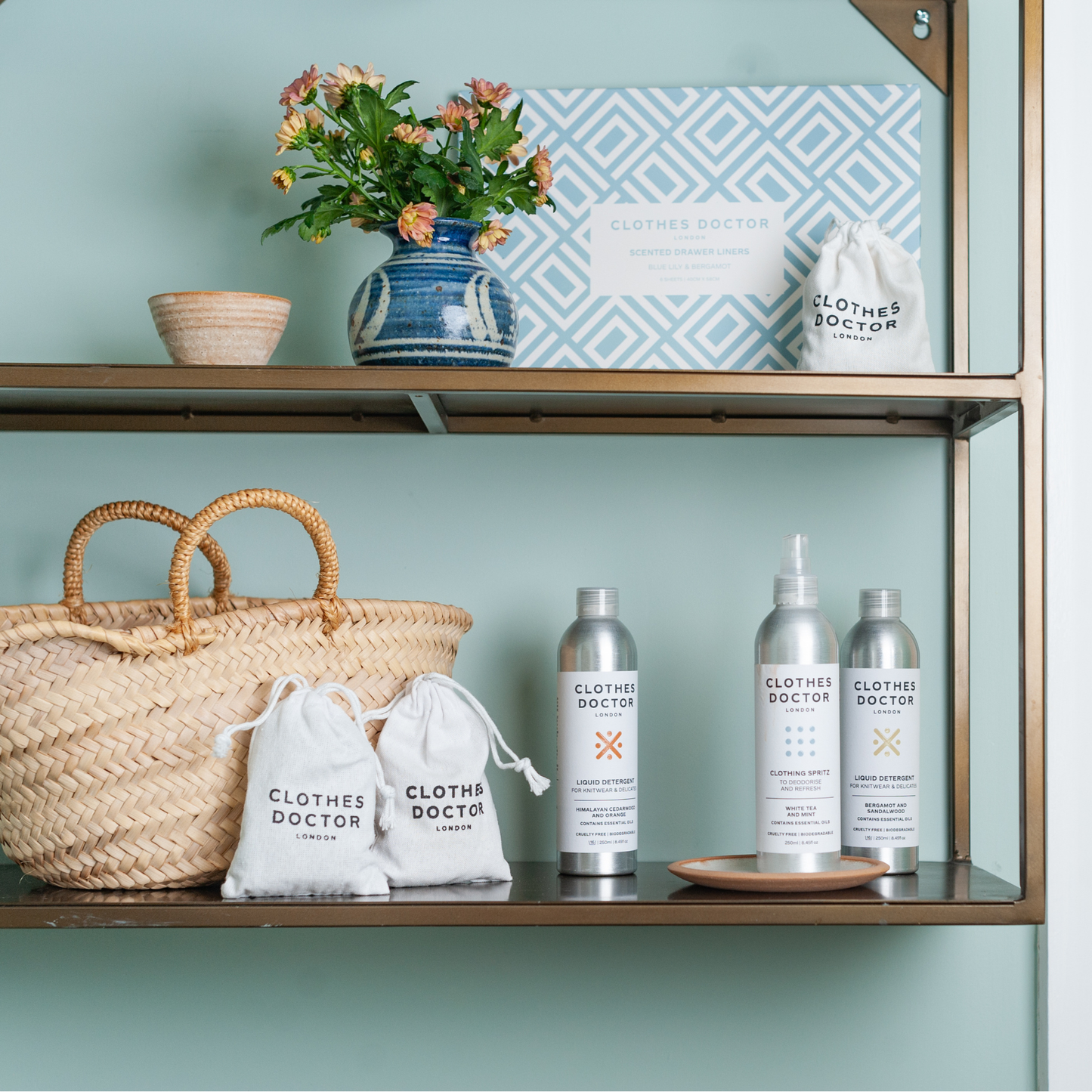 Shelf with 'Clothes Doctor' products, a woven basket, and decorative items against a light blue wall.