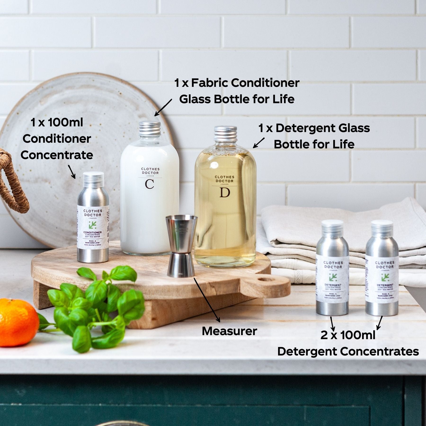 Set of cleaning products including bottles and concentrates on a kitchen counter.