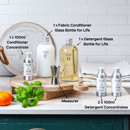 Set of cleaning products including bottles and concentrates on a kitchen counter.