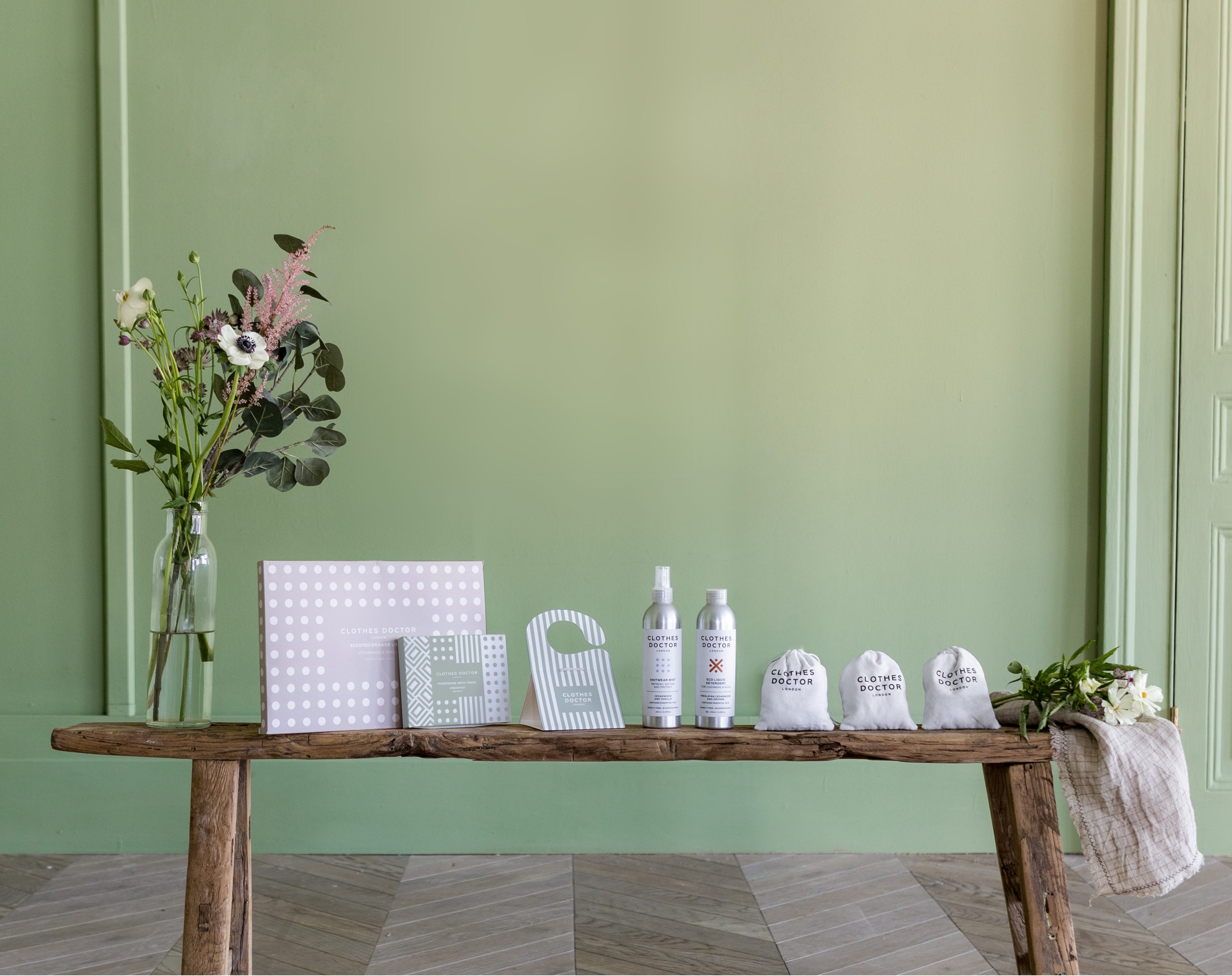 Wooden table with decorative items against a green wall